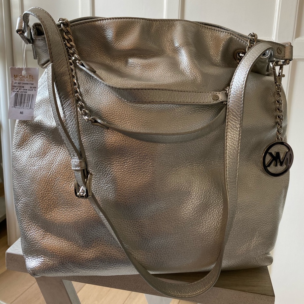 Michael Kors silver bag with strap.